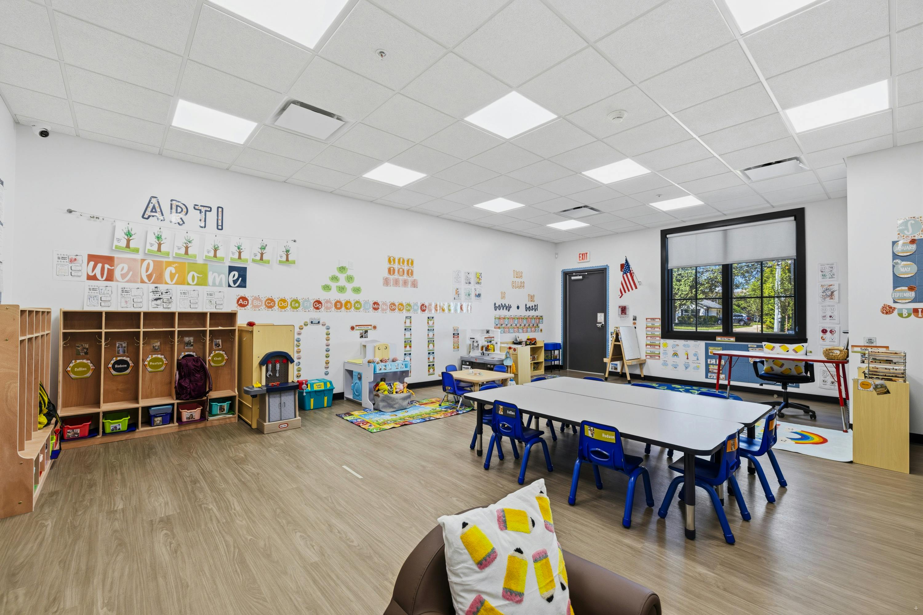 Classroom with tables and chairs for children, storage cubbies, and decorations