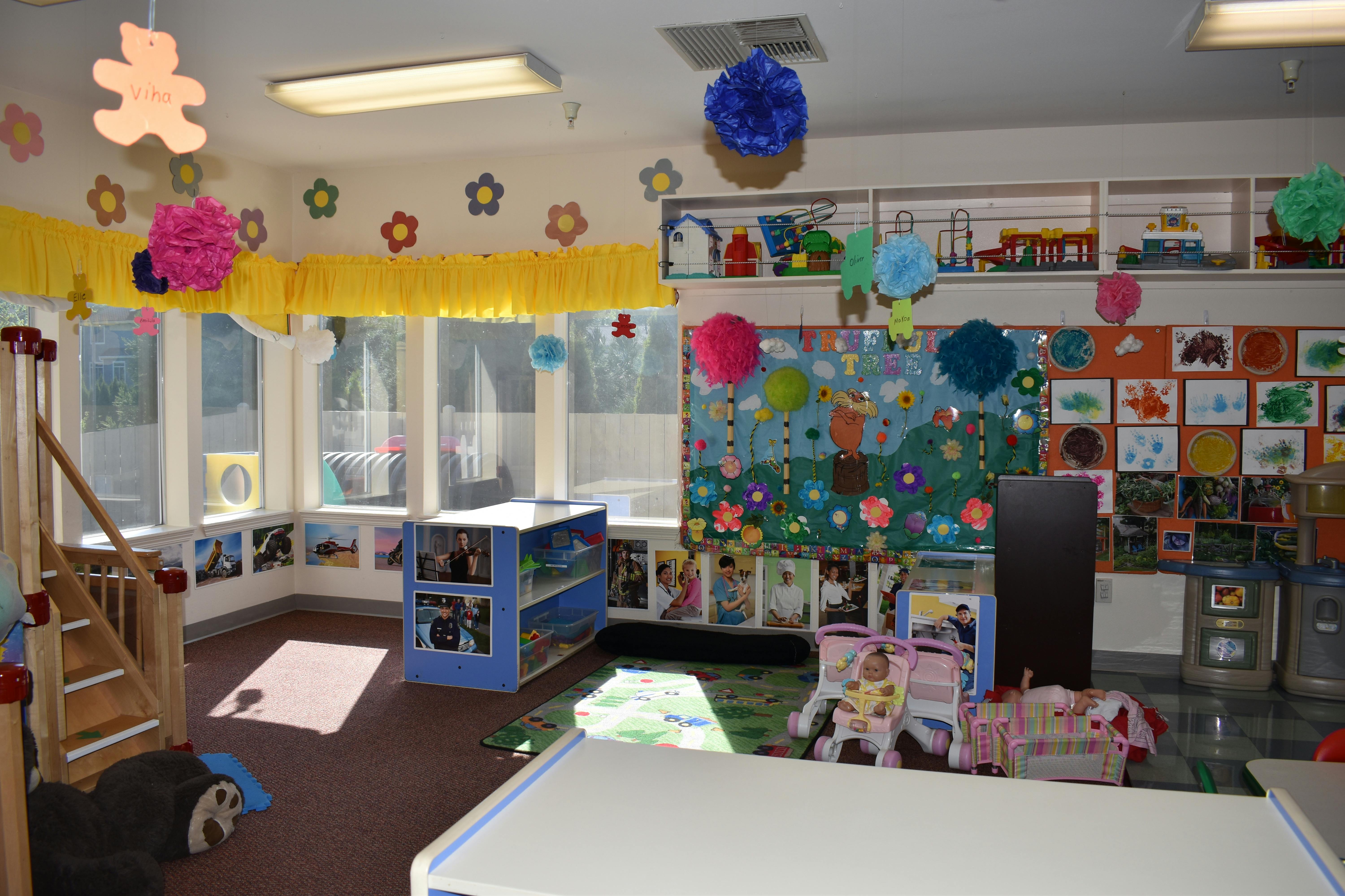 A colorful classroom with decorations, windows, and children's artwork