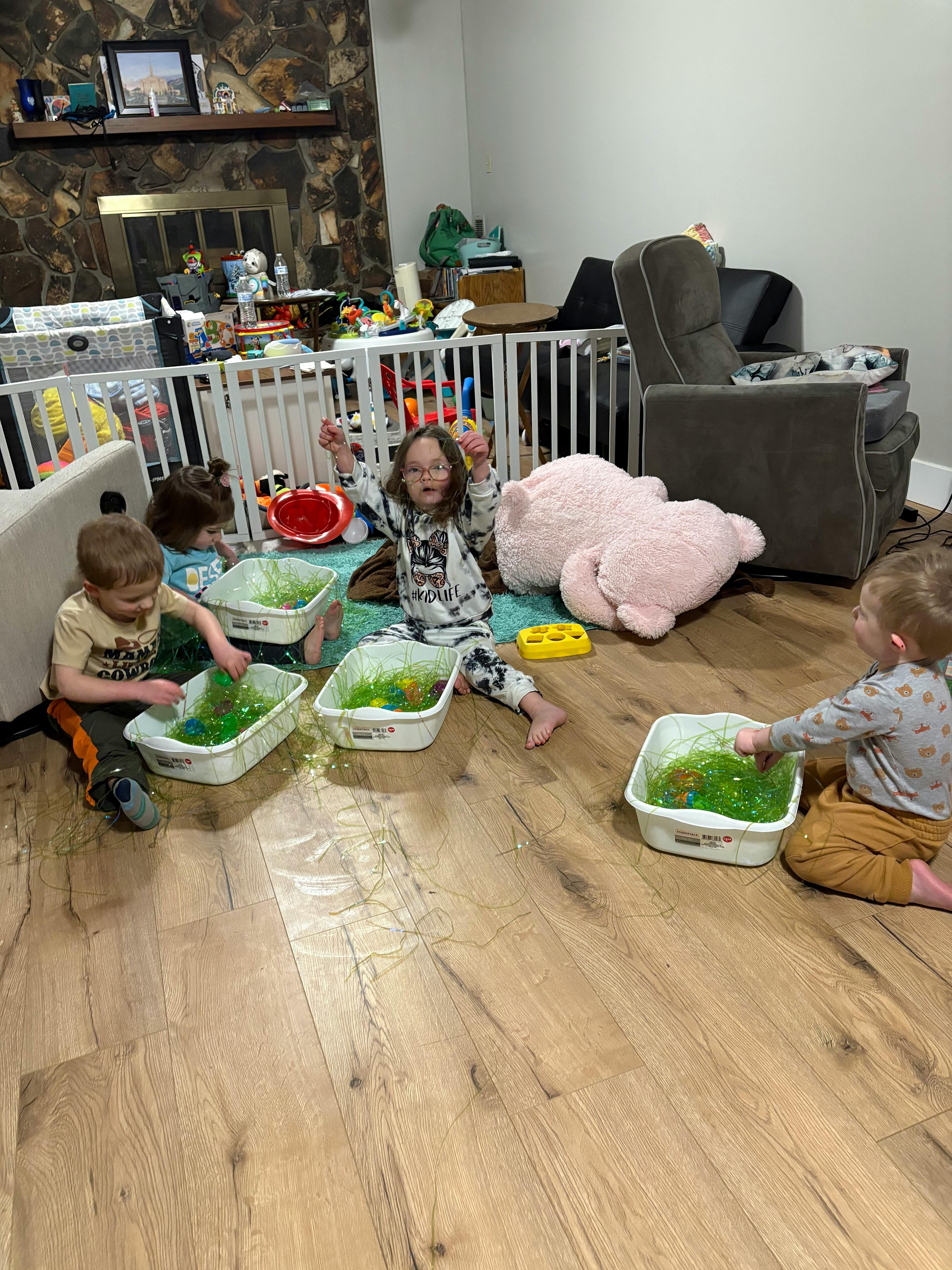 Children playing with sensory bins on the floor