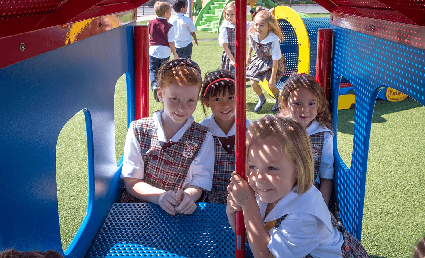 Children in uniform playing on playground equipment