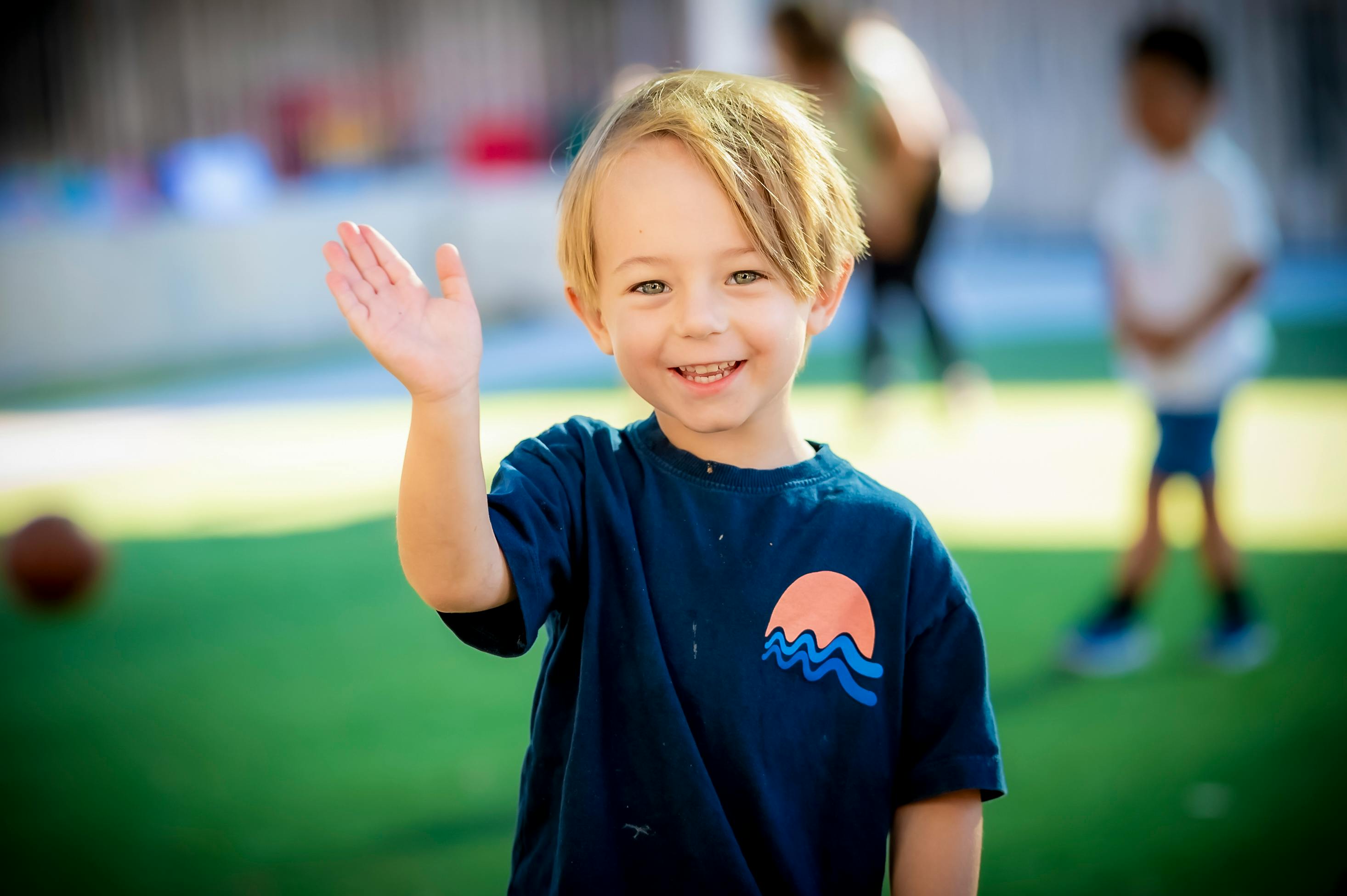 Child waving with one hand