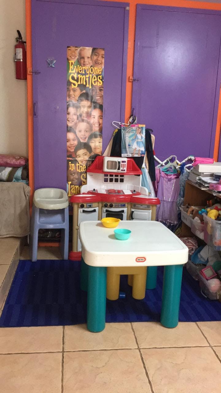 Play kitchen and small table with bowls in a room with purple doors