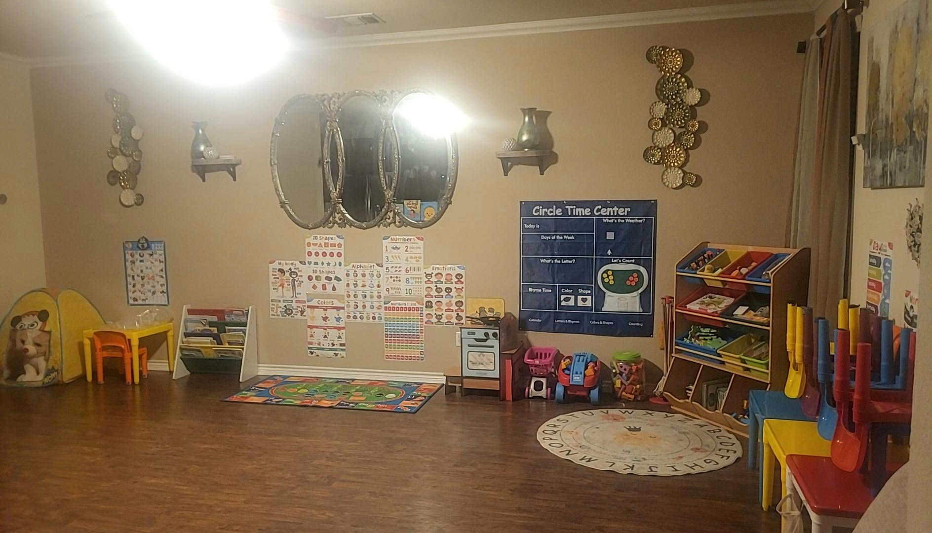 Playroom with toys, small tables, and educational posters