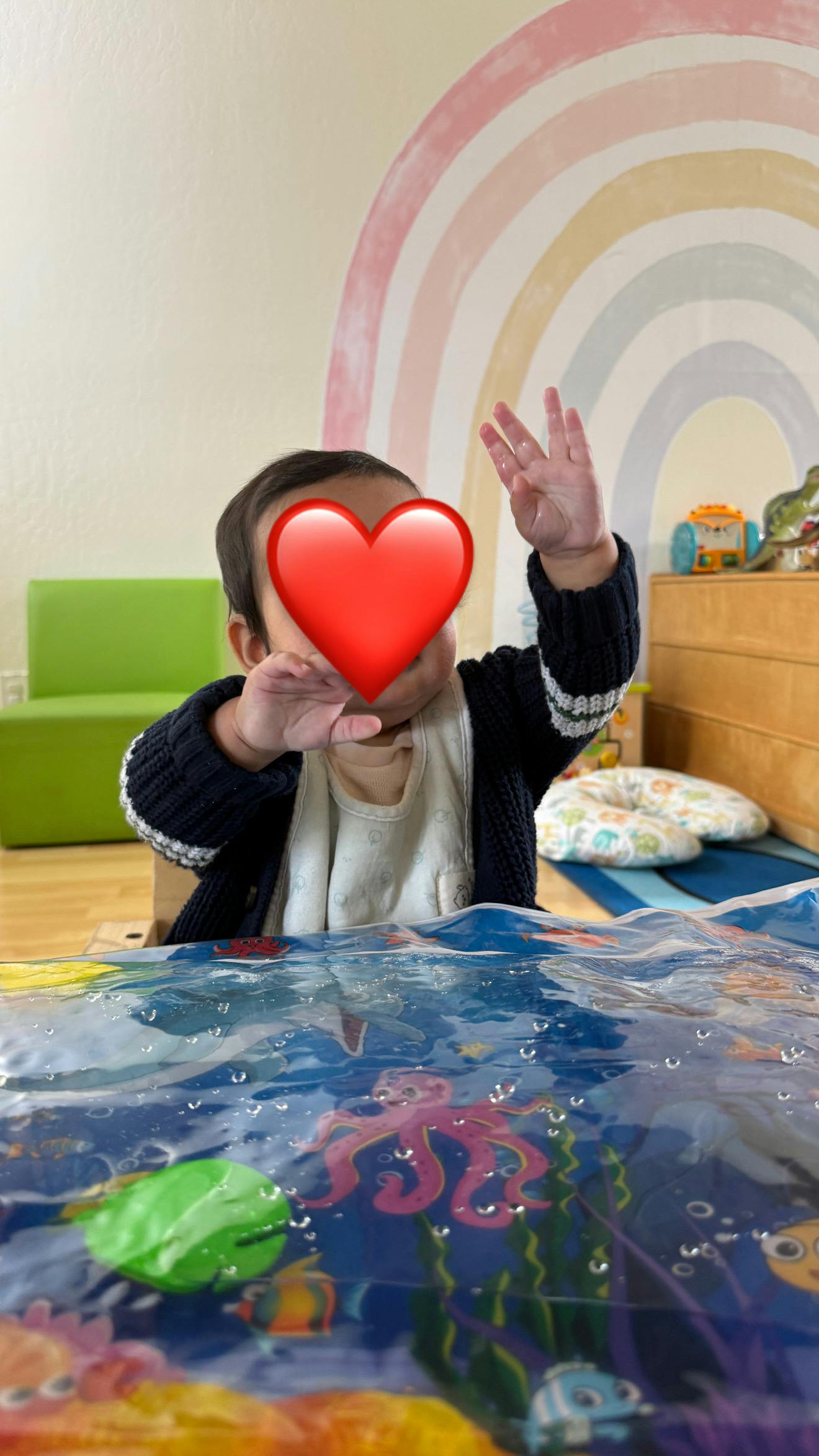 Child sitting and playing with an aquatic-themed sensory water mat