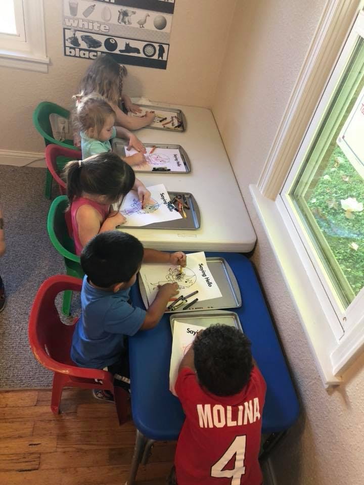 Children drawing at tables in a classroom