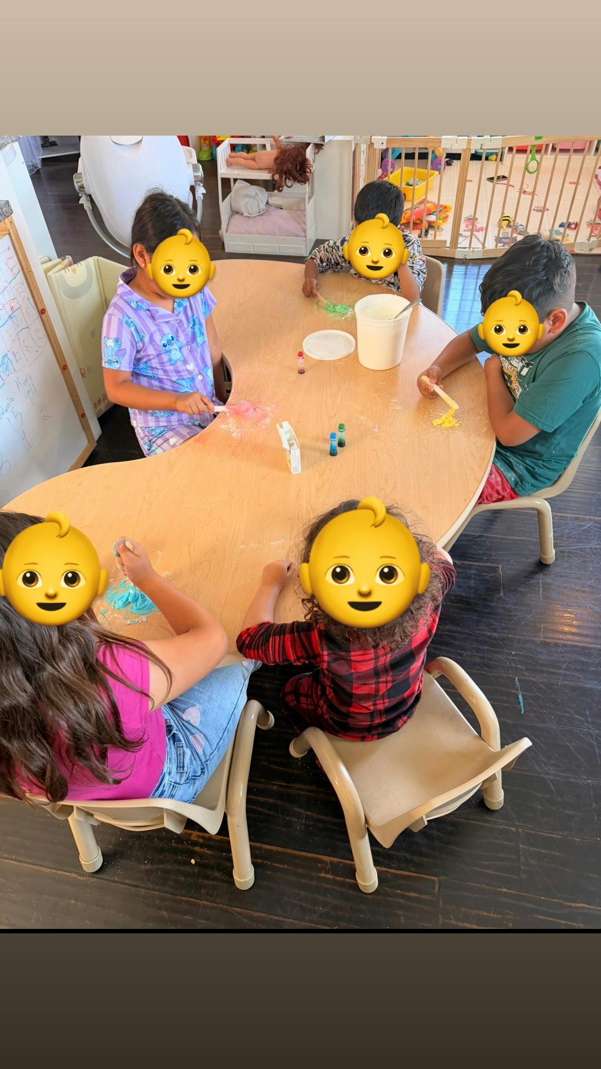 Group of children seated around a table participating in a craft activity