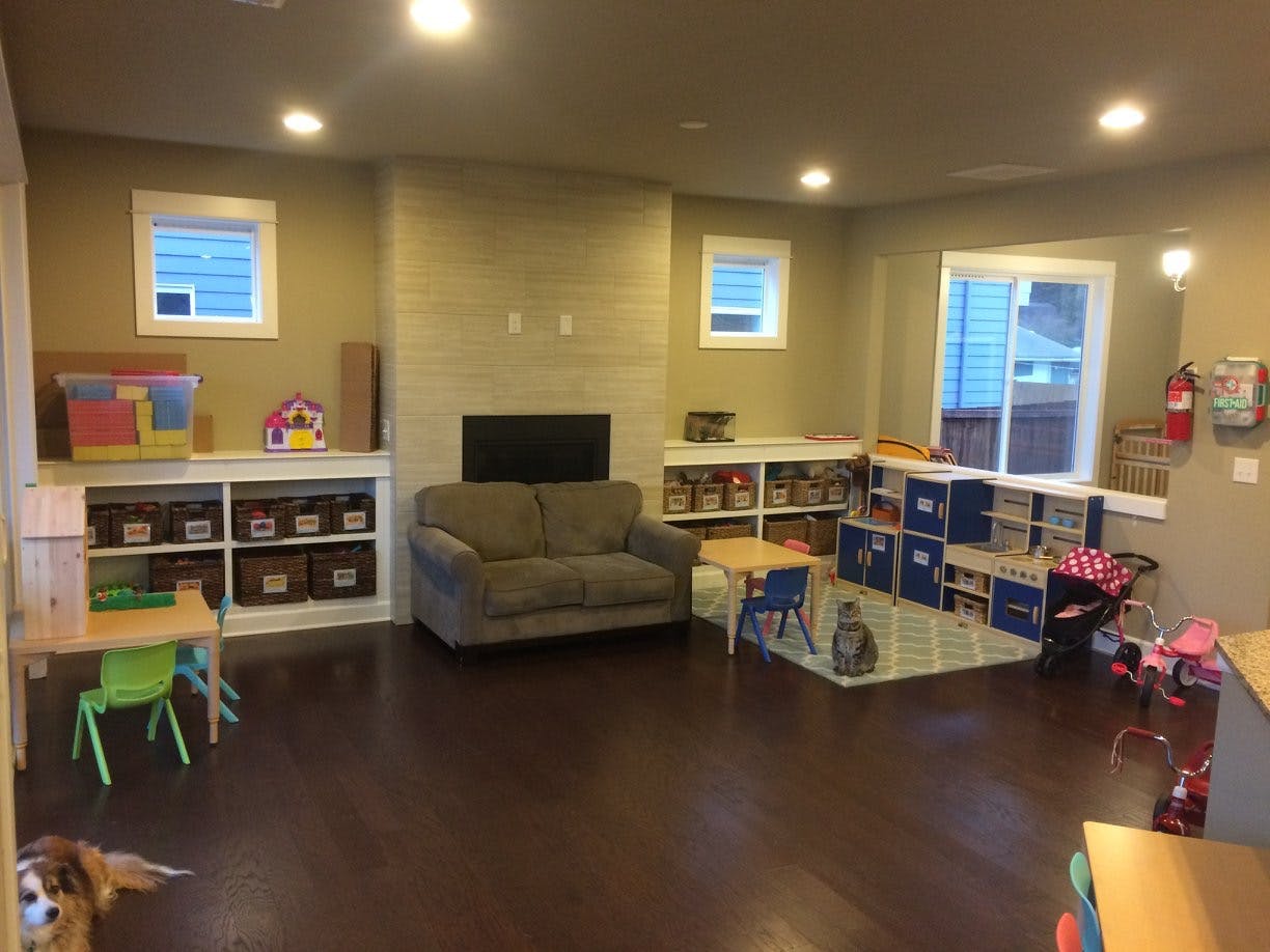 Playroom with a sofa, shelves, and small tables