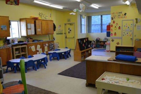 Classroom with small tables and chairs, cabinets, and windows