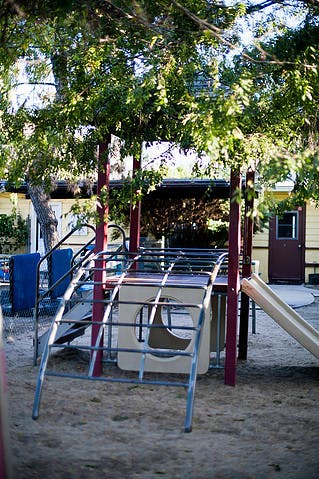 Playground with monkey bars, slide, and sand