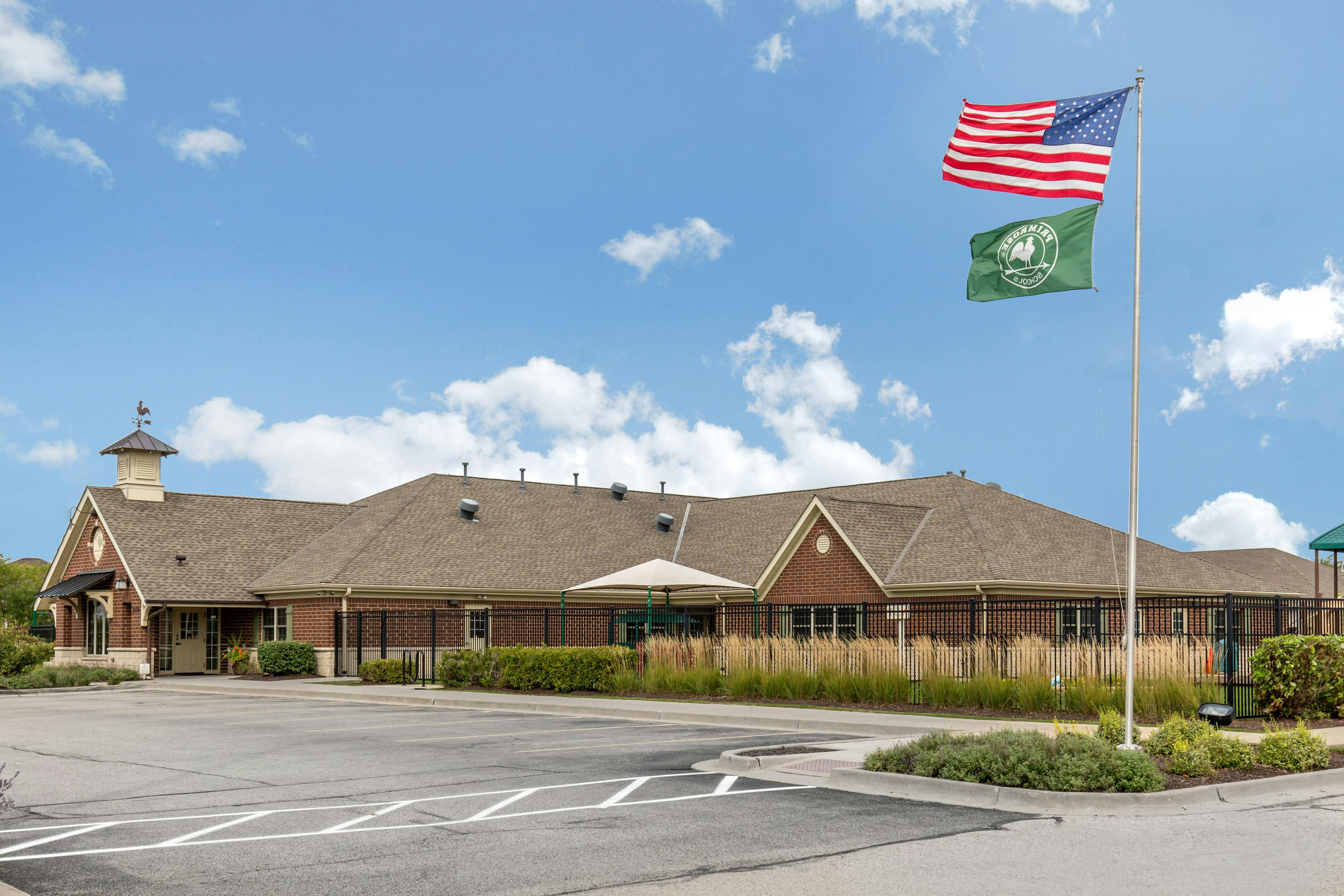 Brick building with a brown roof and a flagpole flying an American flag