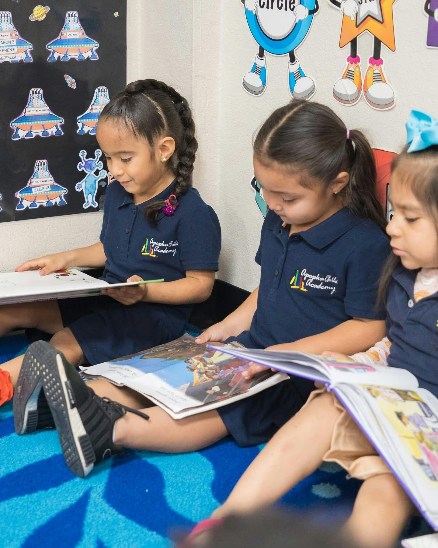 Three children sitting on the floor reading books