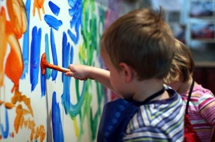 Child painting on a canvas with a brush