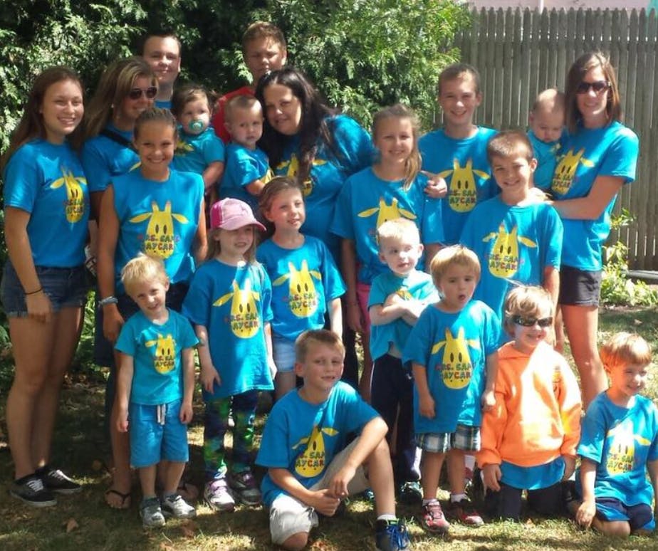 Group of adults, teens, and children in matching blue t-shirts