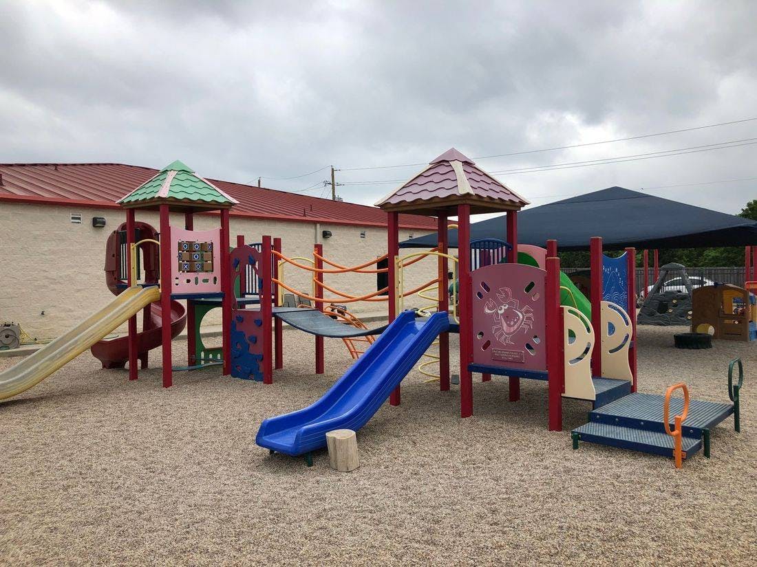 Playground with slides, climbing structures, and a rope bridge
