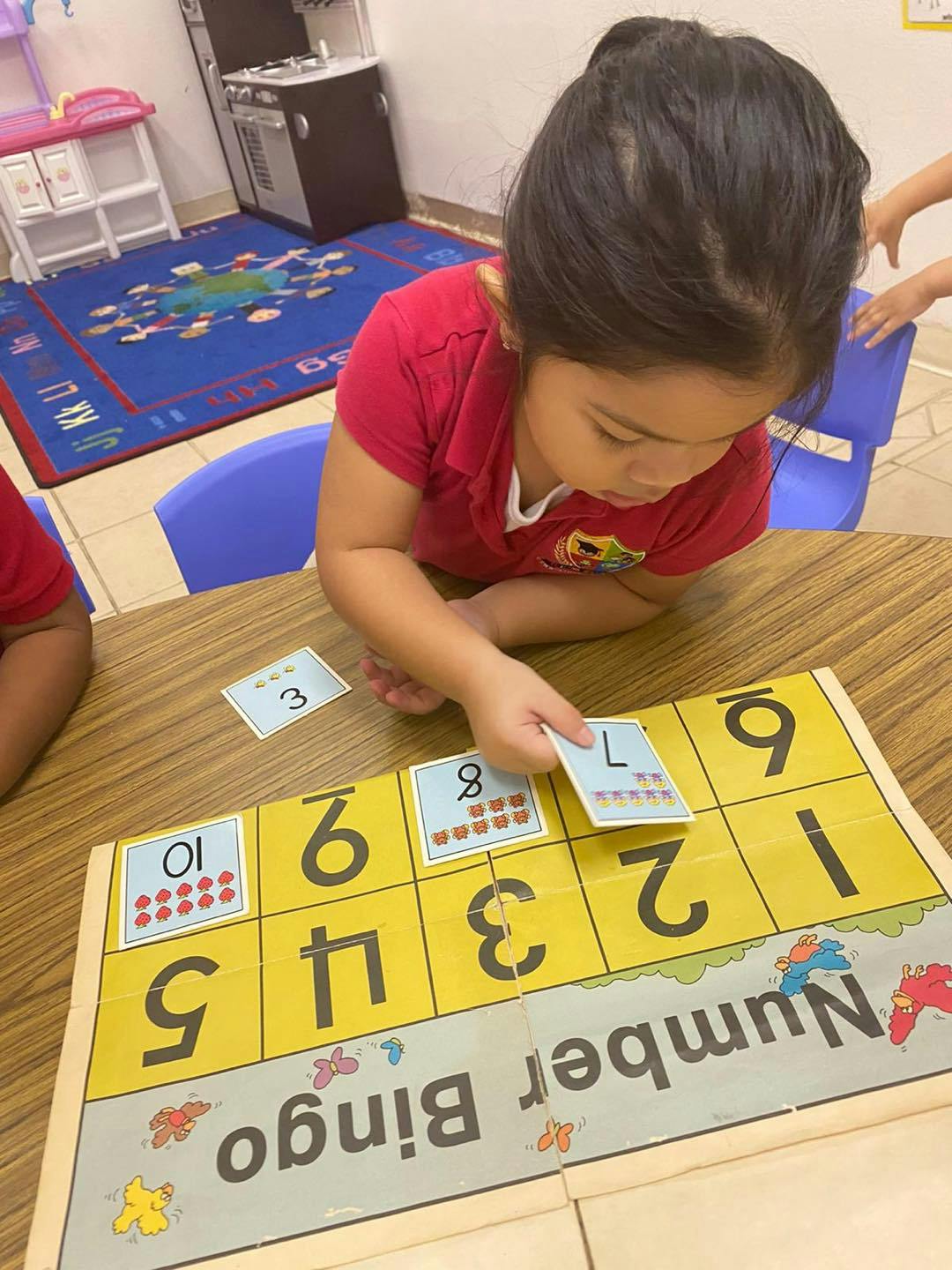 Child playing Number Bingo at a table