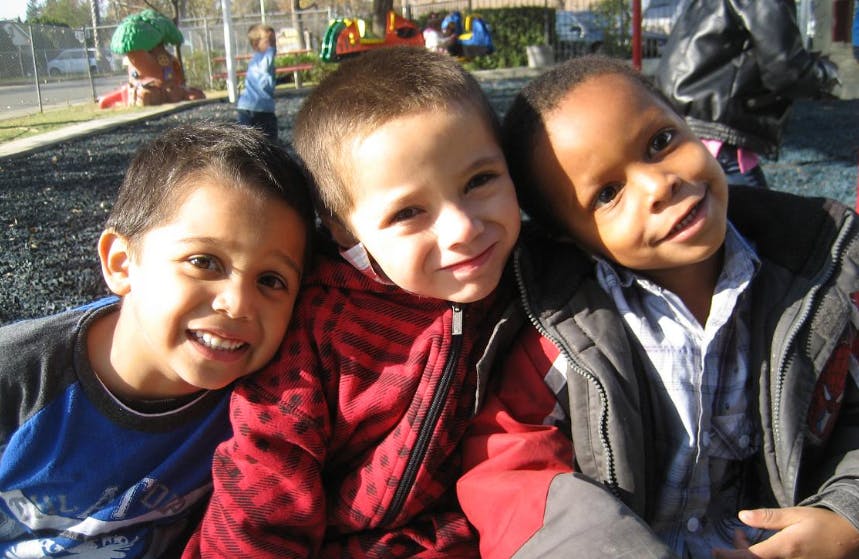 Three children posing together on a playground