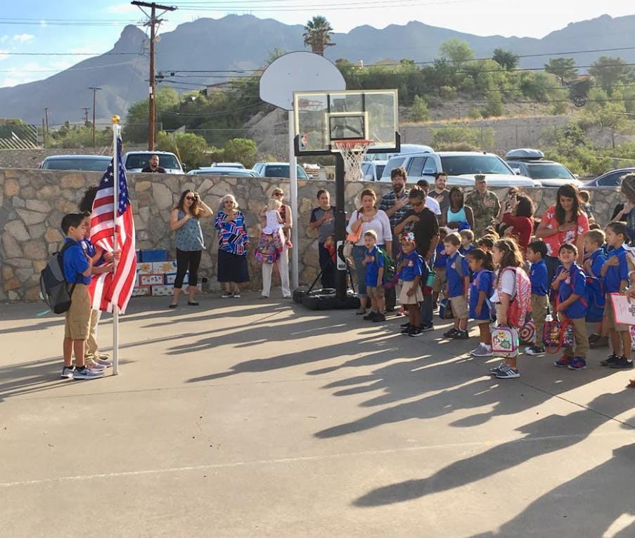 People and children gathered around an American flag