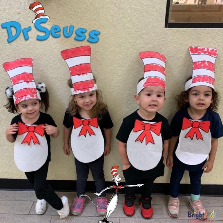 Four children dressed in red and white striped hats and red bow ties