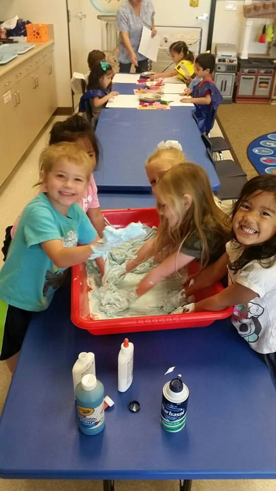 Children playing with a sensory bin in a classroom