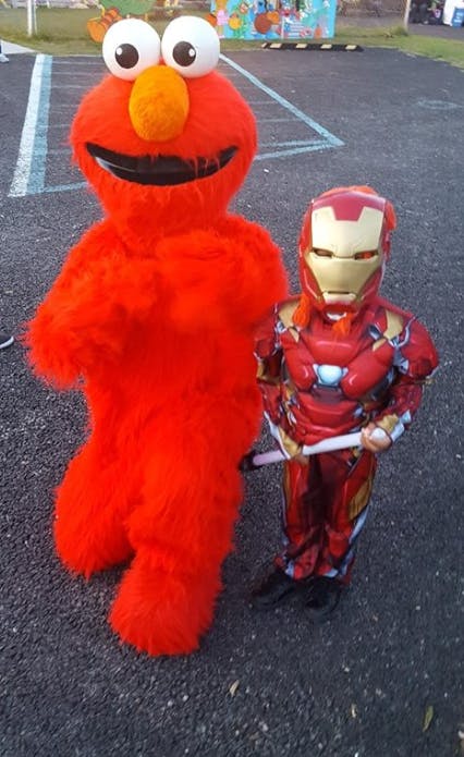 Person in red monster costume next to child in Iron Man costume