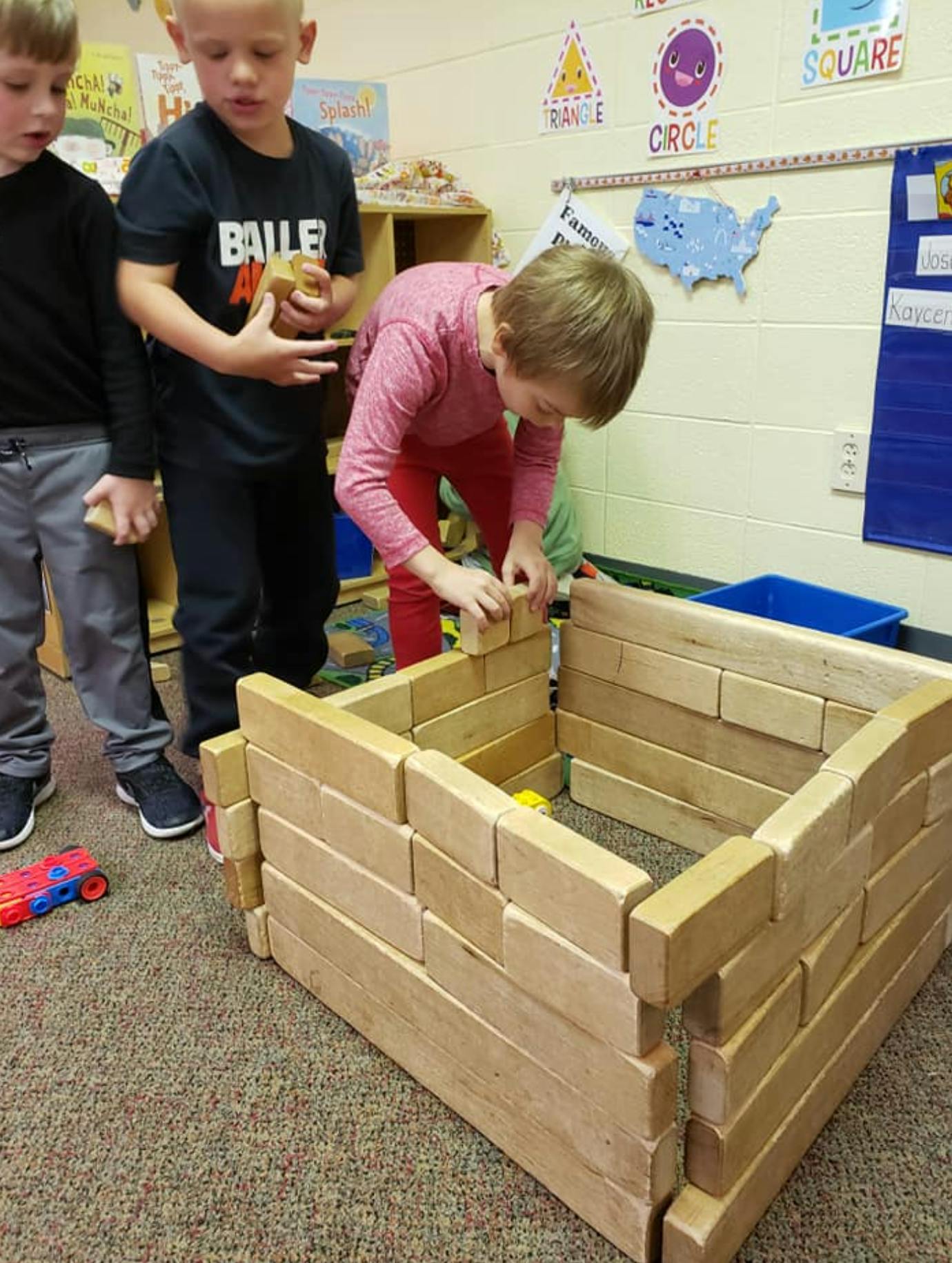 Child building with wooden blocks in a classroom
