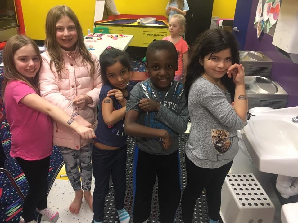 Five children posing together indoors