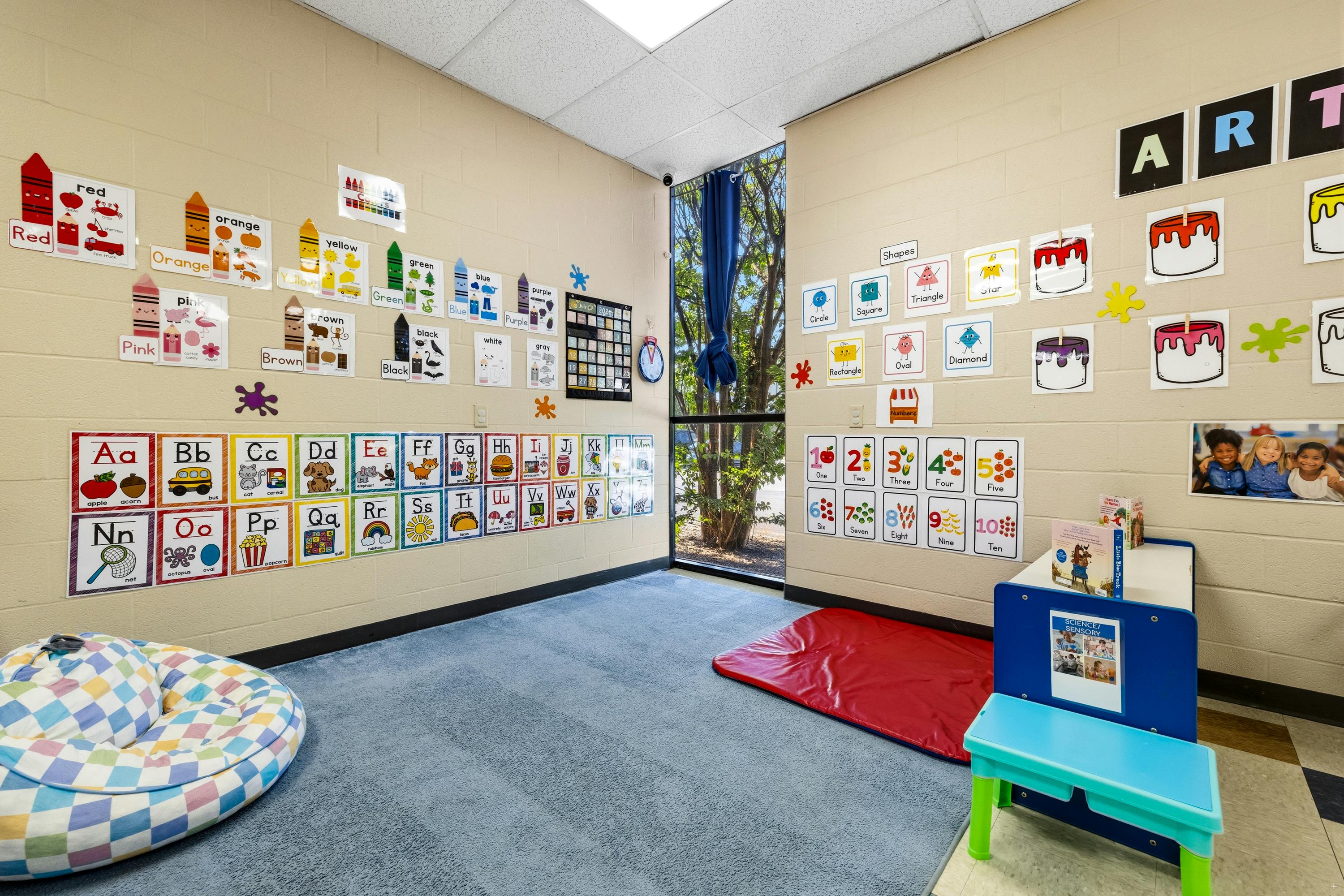 Classroom interior with educational alphabet and number charts on brick walls