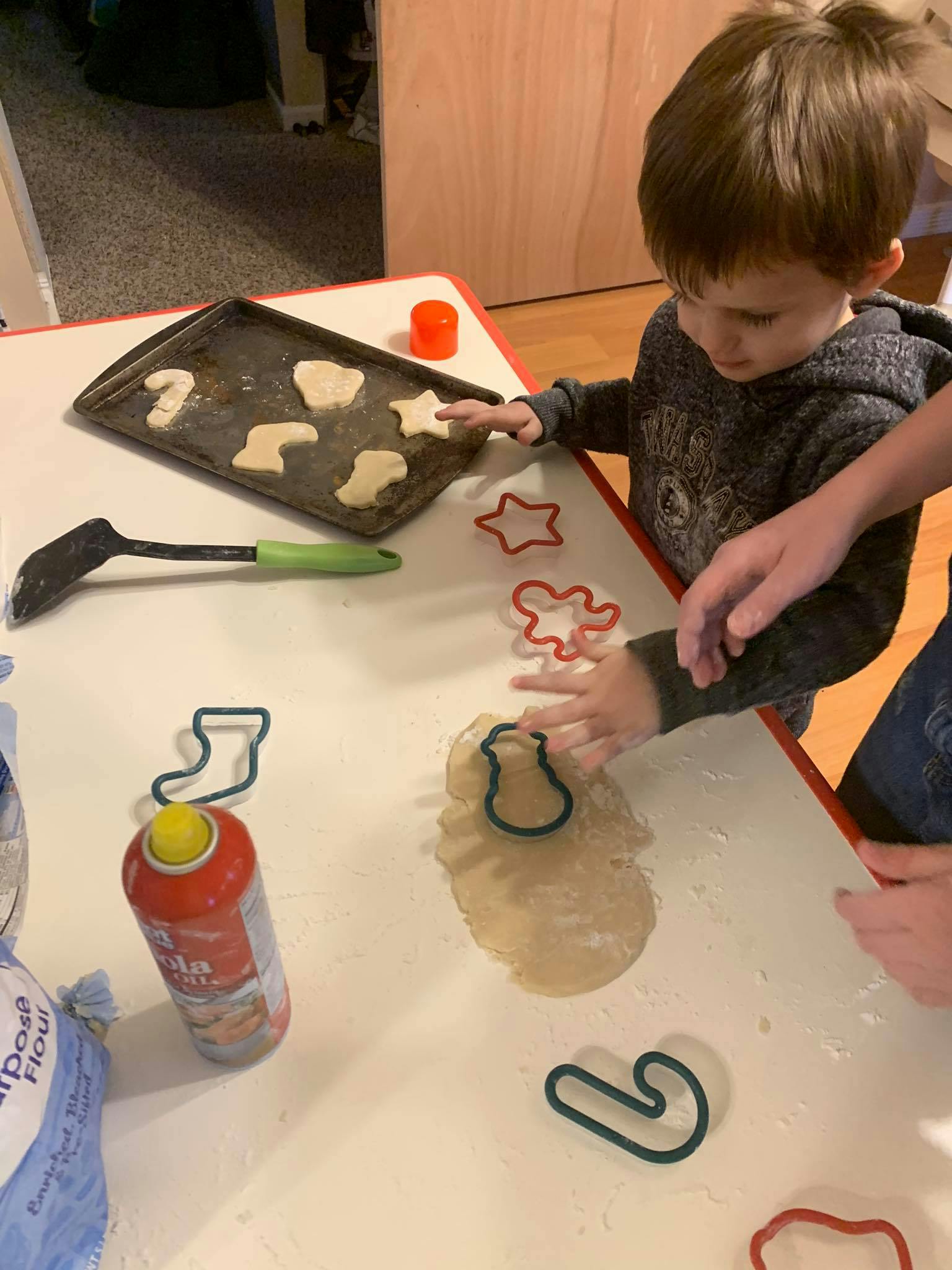 Child using cookie cutters on dough