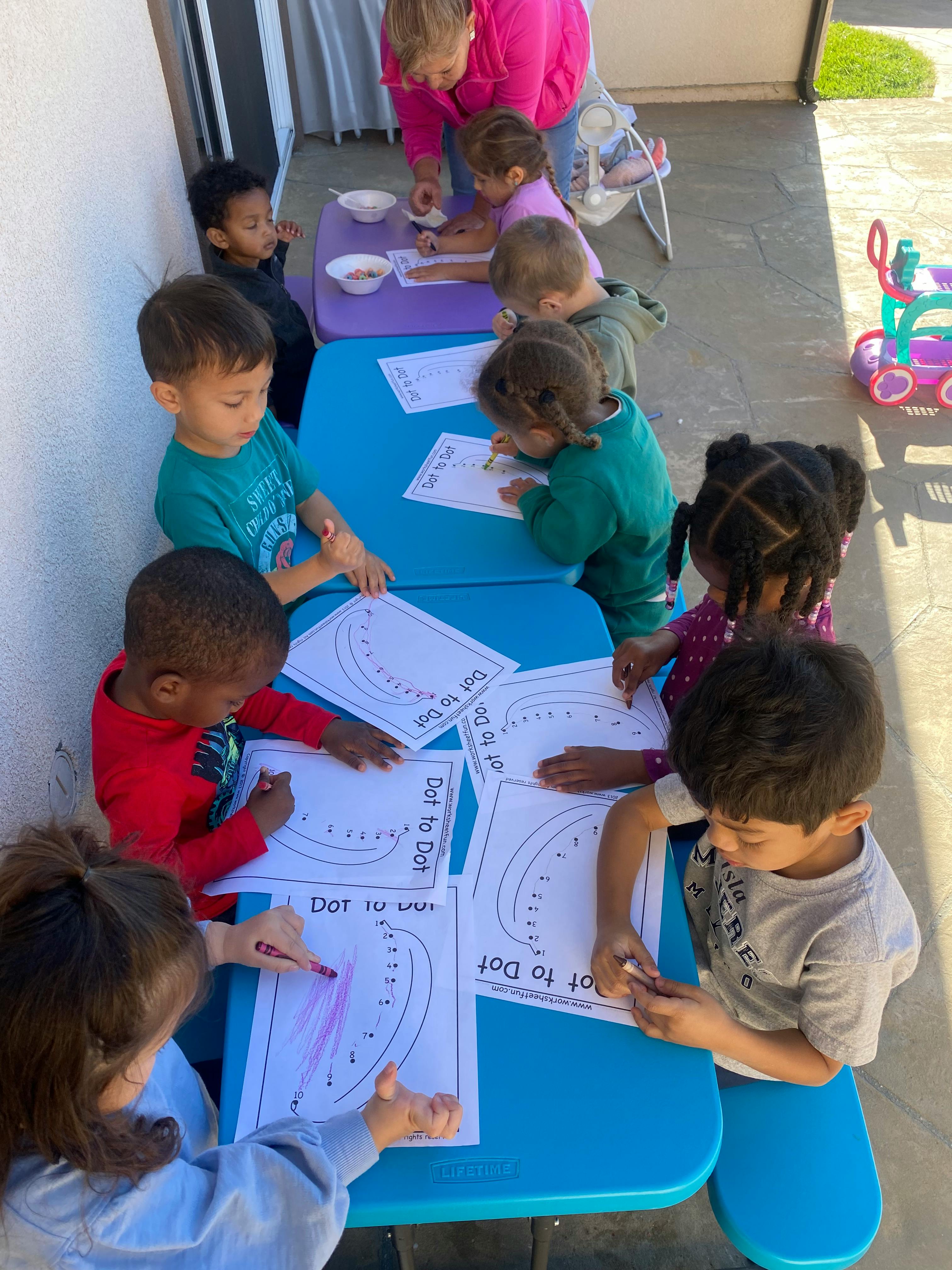 Children sitting at tables doing a "Dot to Dot" activity