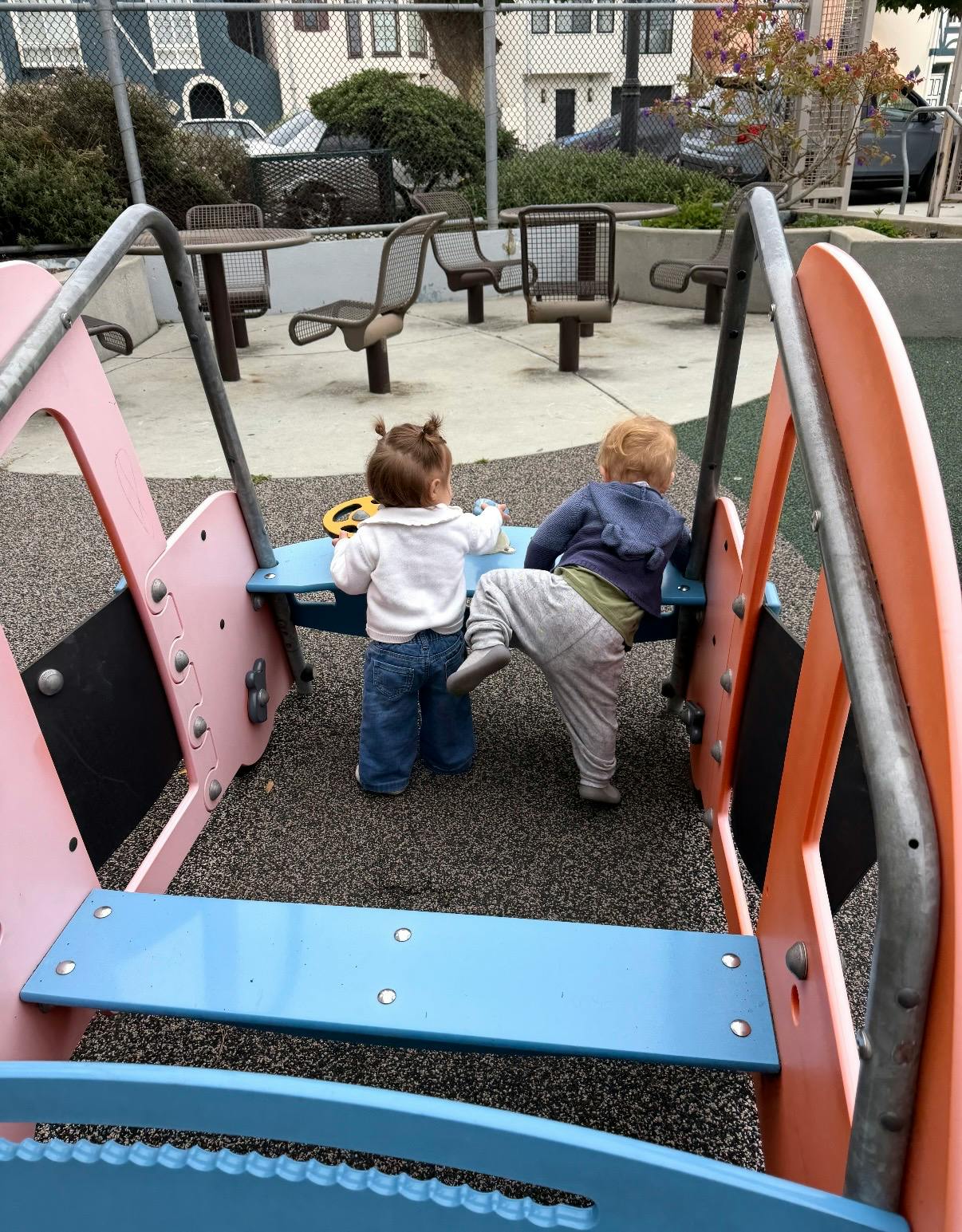 Two children playing on a playground structure