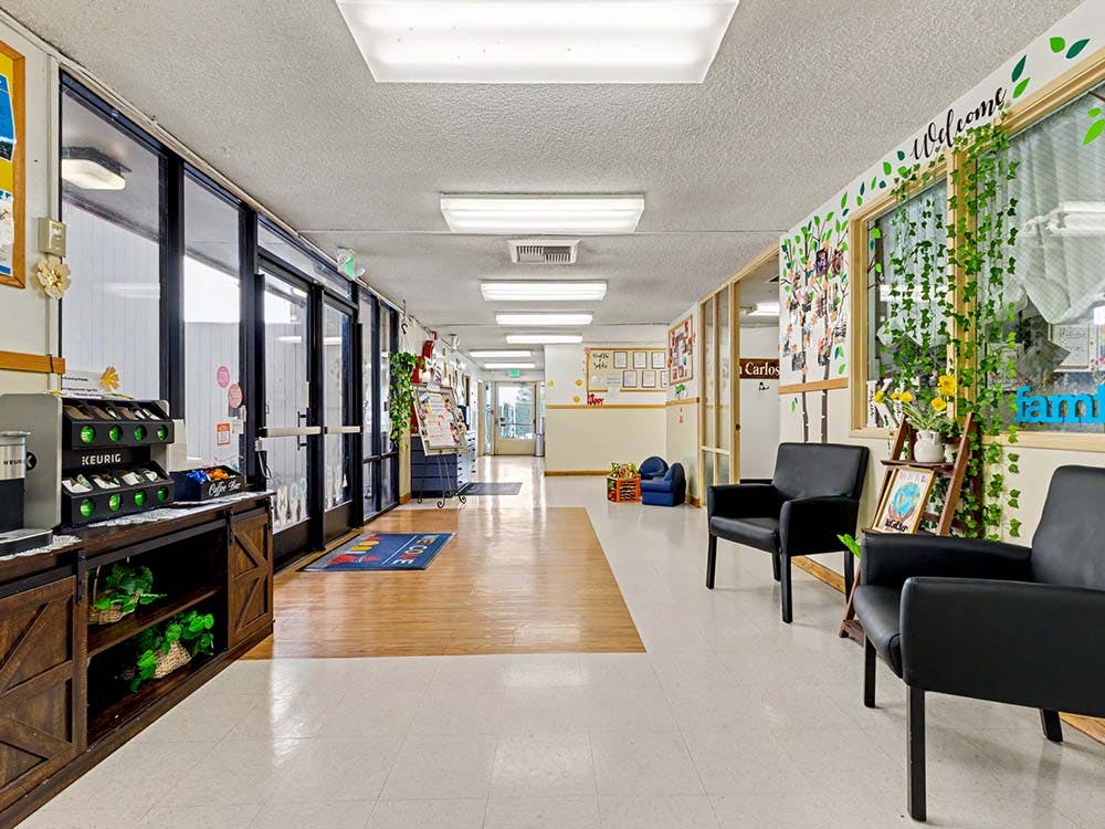 Hallway with a coffee station, black chairs, and decorated windows