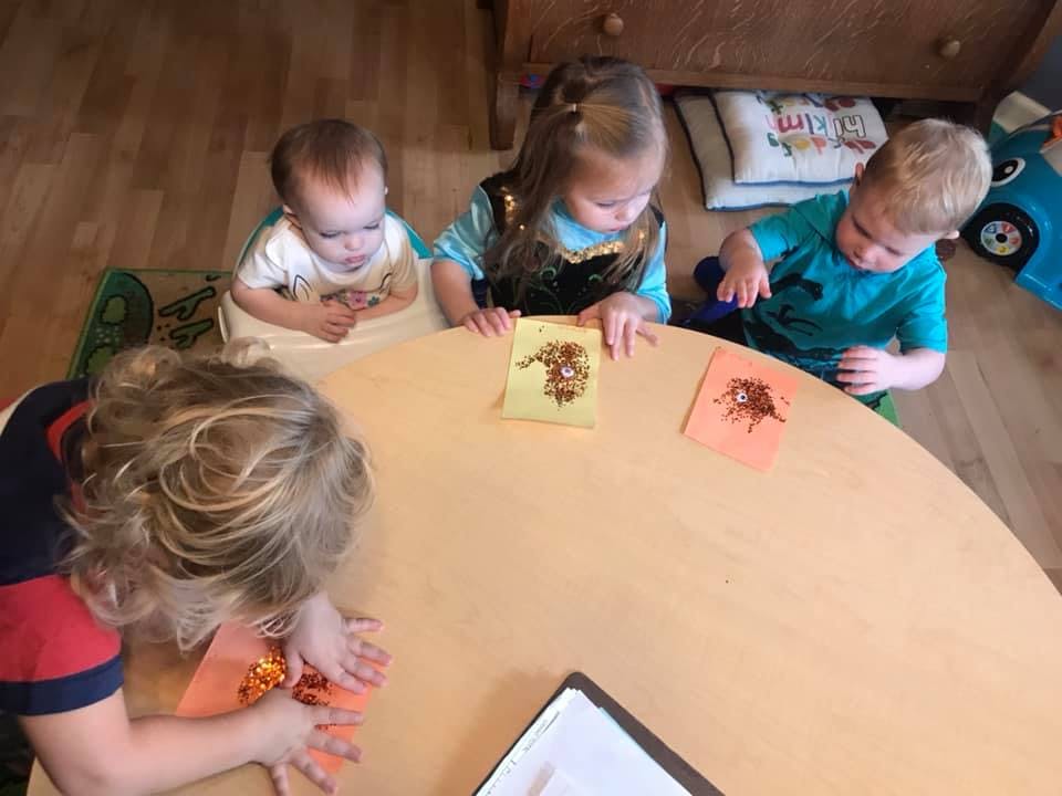 Four children sitting around a table with cards