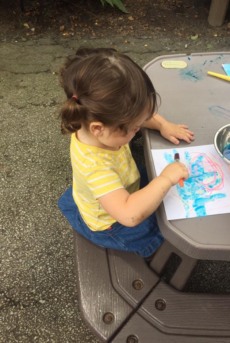 Child drawing on paper at a table