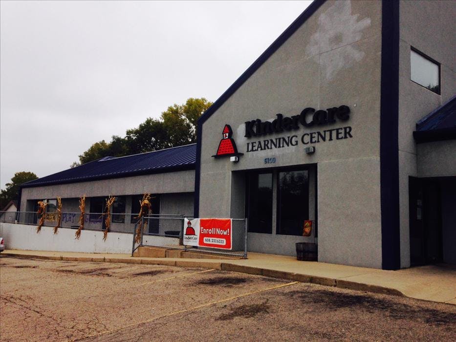 KinderCare Learning Center building with an "Enroll Now!" sign