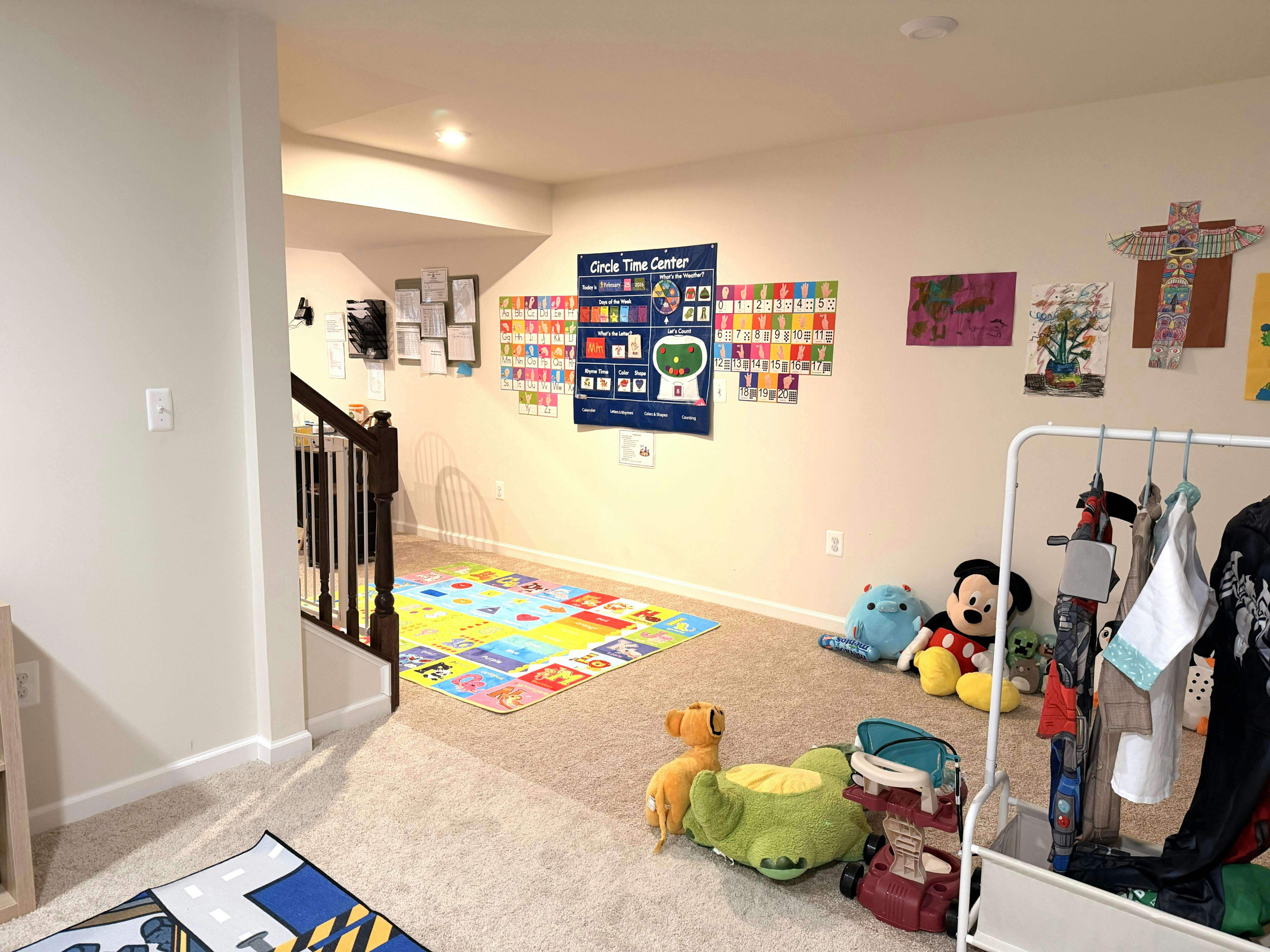 Child's play area with a colorful rug, educational posters, and stuffed animals