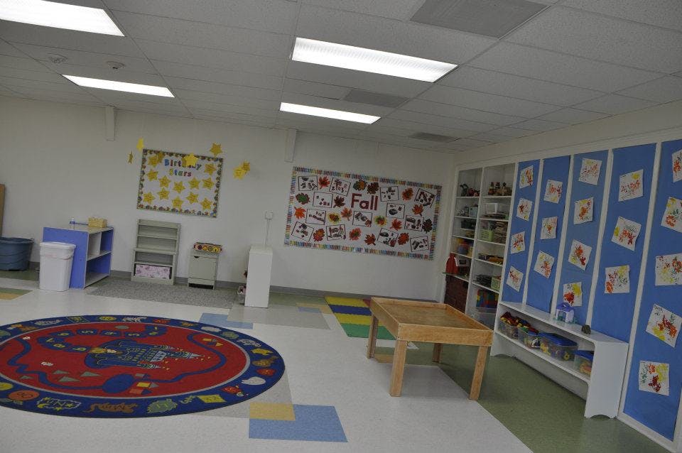 Empty classroom with a red circular rug and educational posters