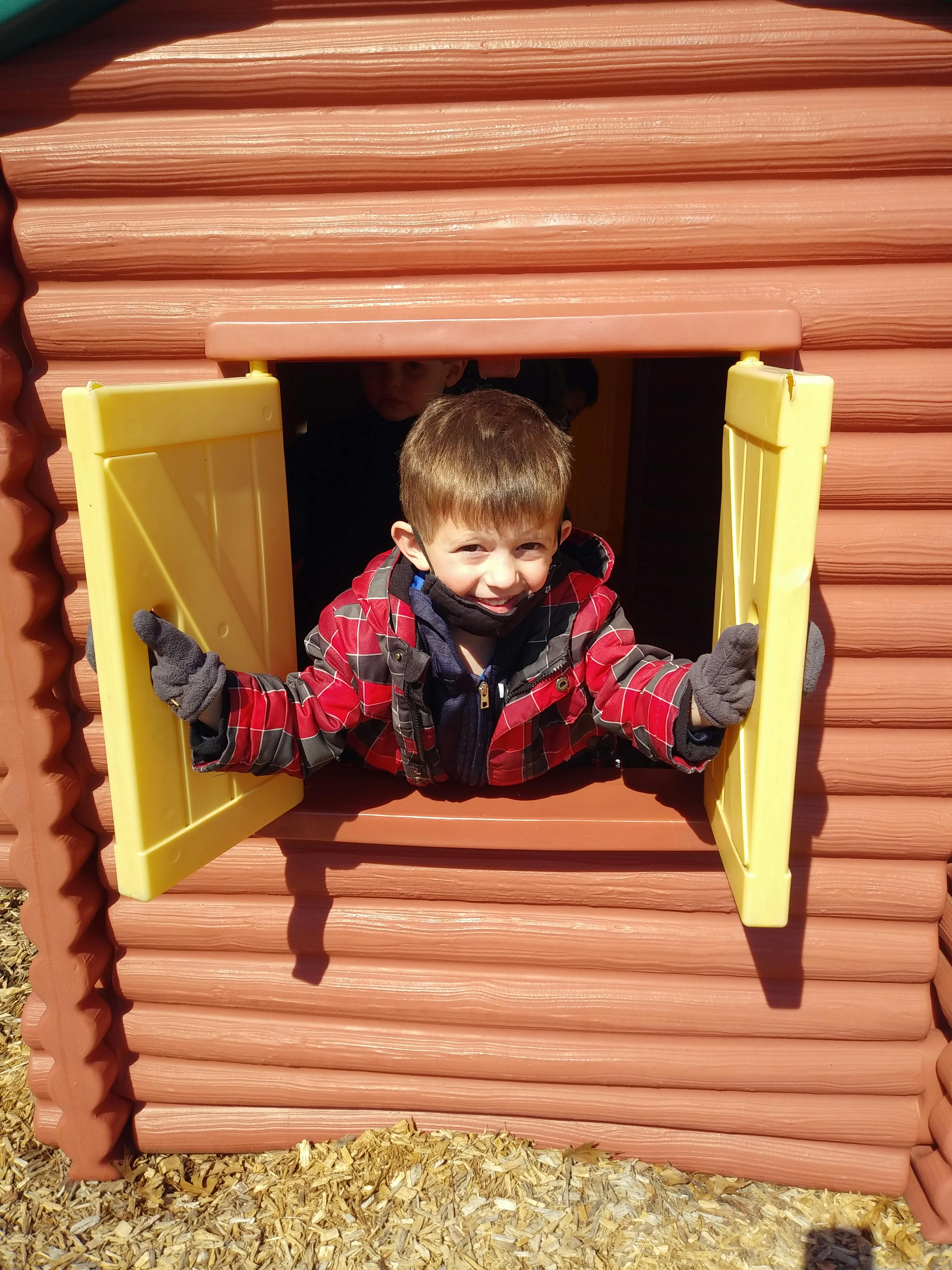Child looking out of a playhouse window