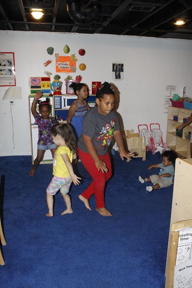 Children playing in a room with blue carpet