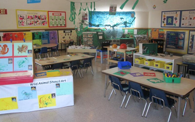 An empty classroom with tables, chairs, and colorful decorations