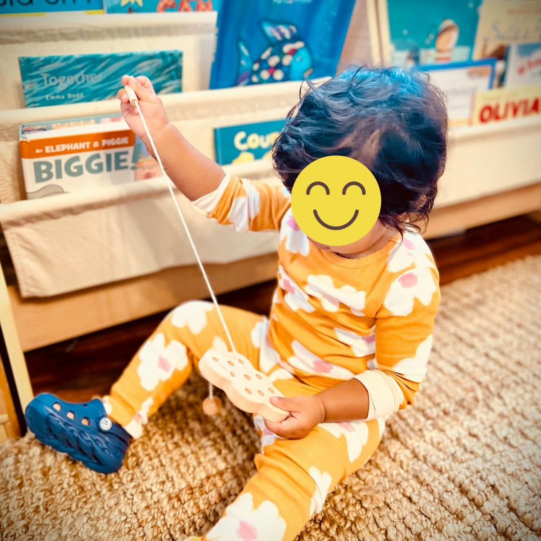 Child playing with a wooden toy on a string