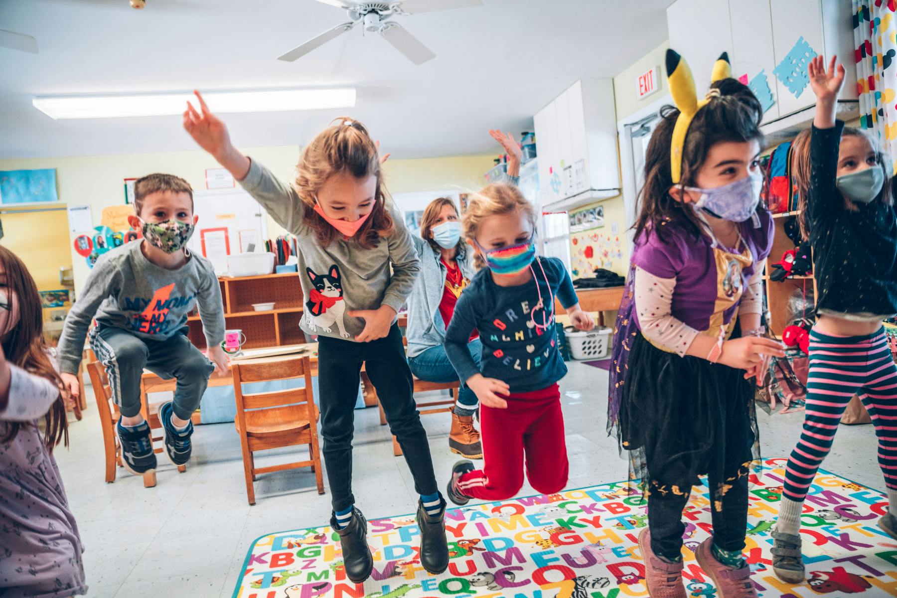 Children jumping and dancing in a classroom