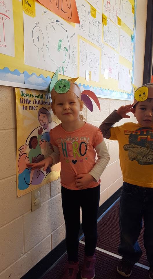 Two children wearing paper headbands