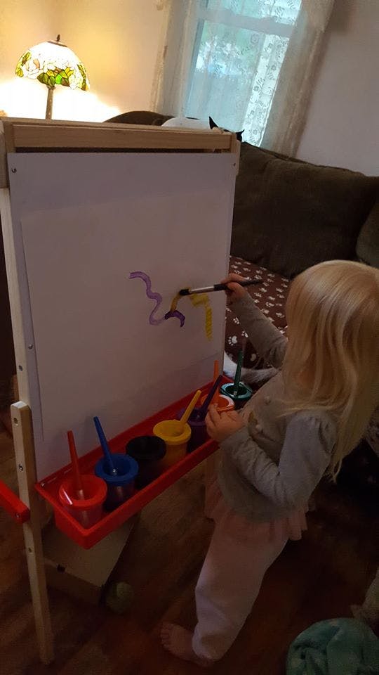 Child painting on an easel