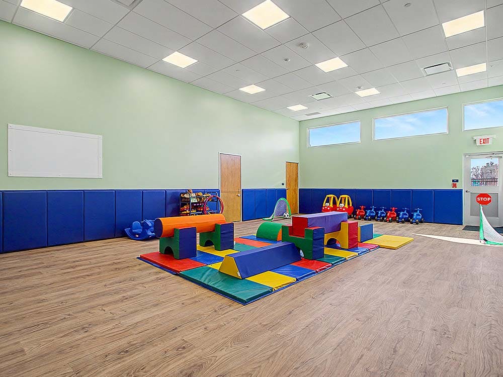 Indoor play area with colorful soft play equipment on a mat
