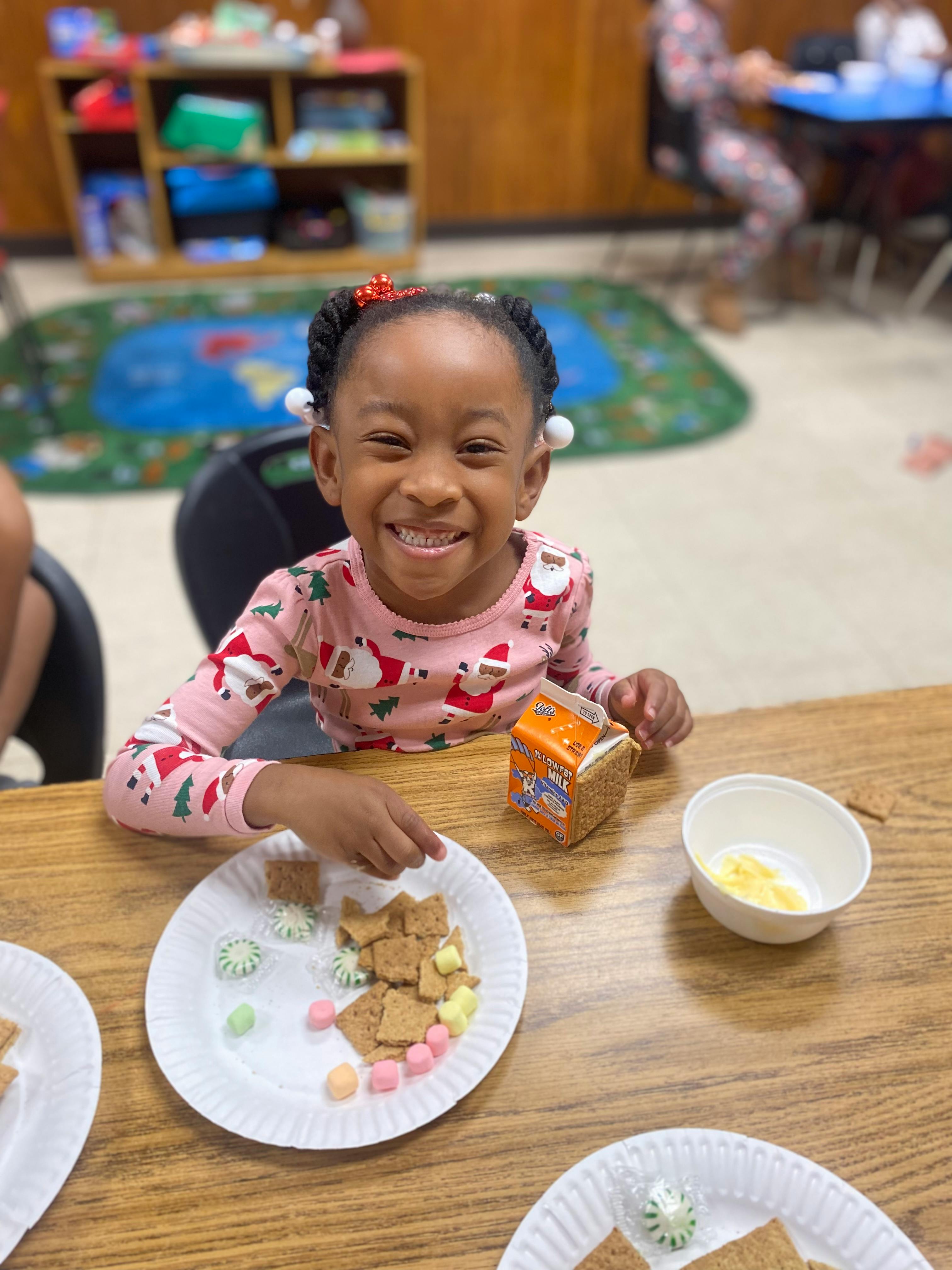 Child at a table with a plate of crackers and candy