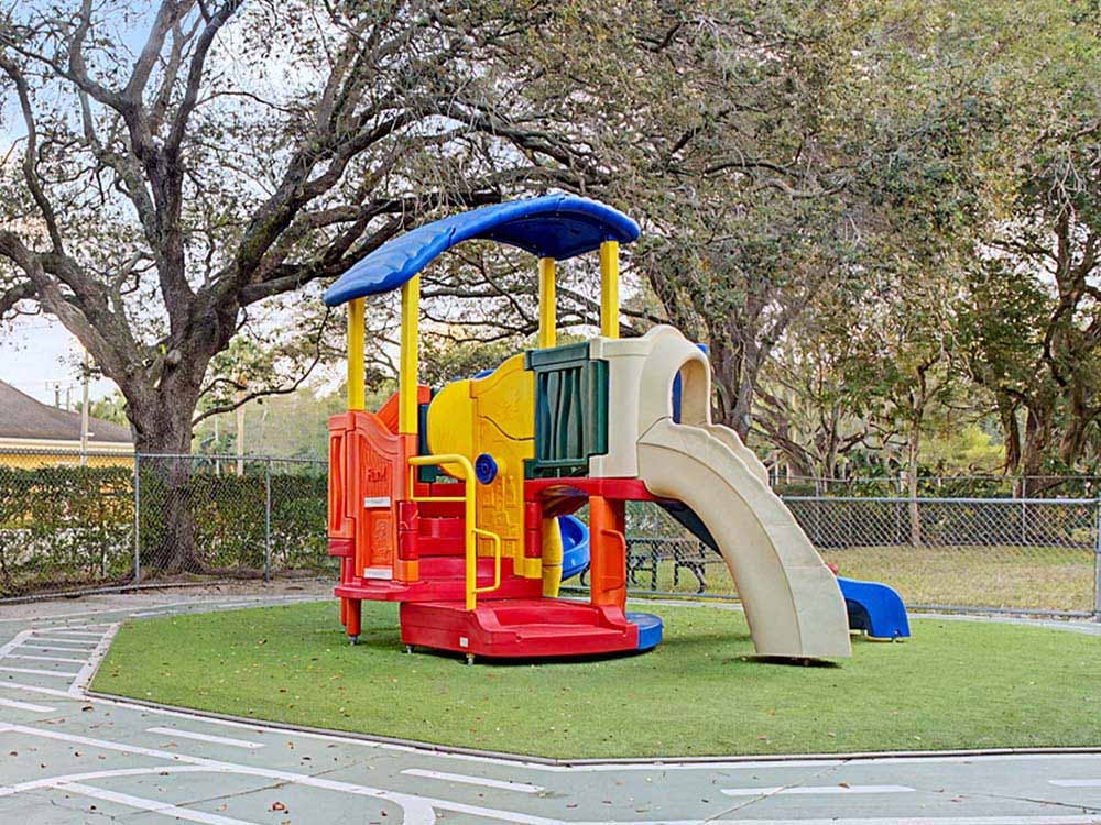 Colorful playground structure with slides on artificial turf