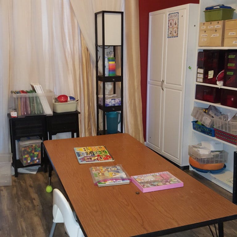 Table with books in a room with shelves and cabinets