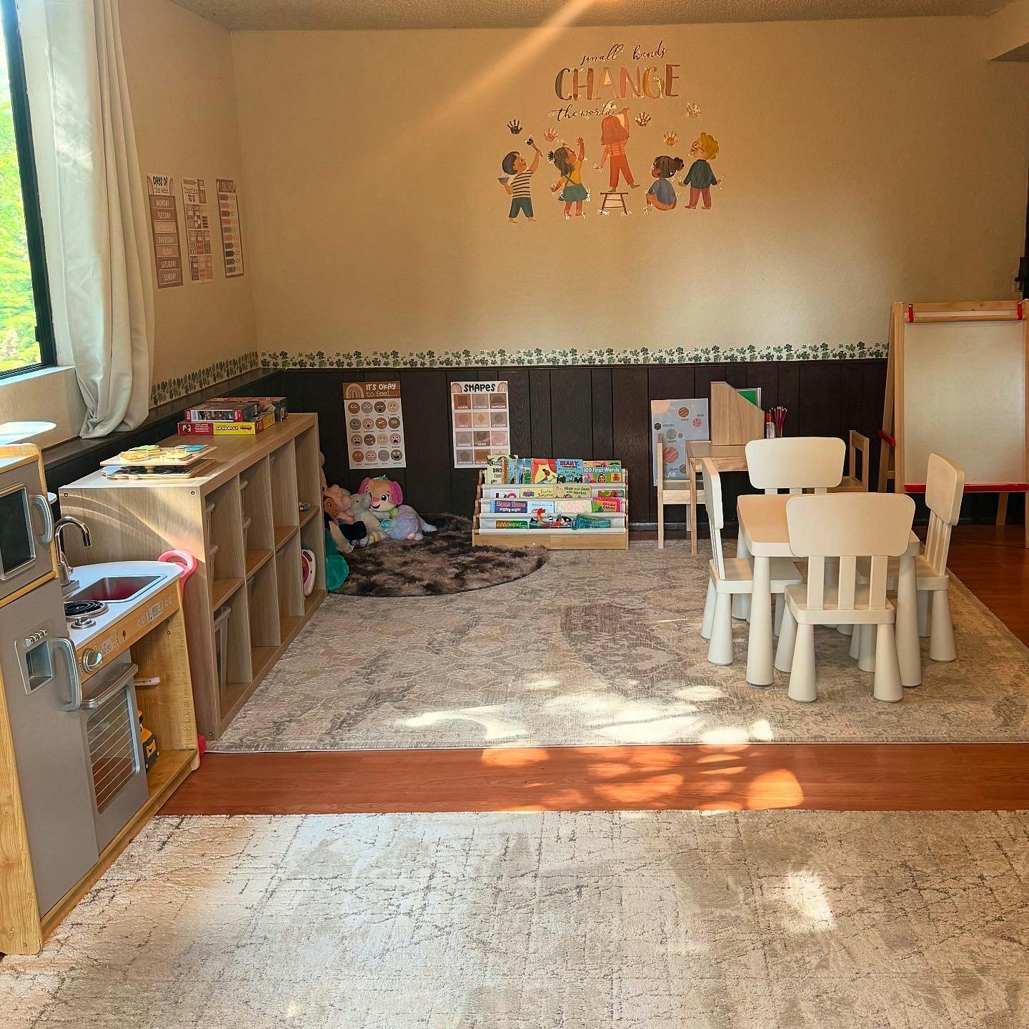 Playroom with small table and chairs, toy kitchen, and bookshelves