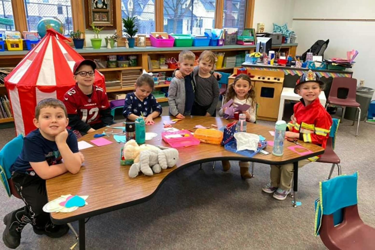 Children sitting at a table in a classroom