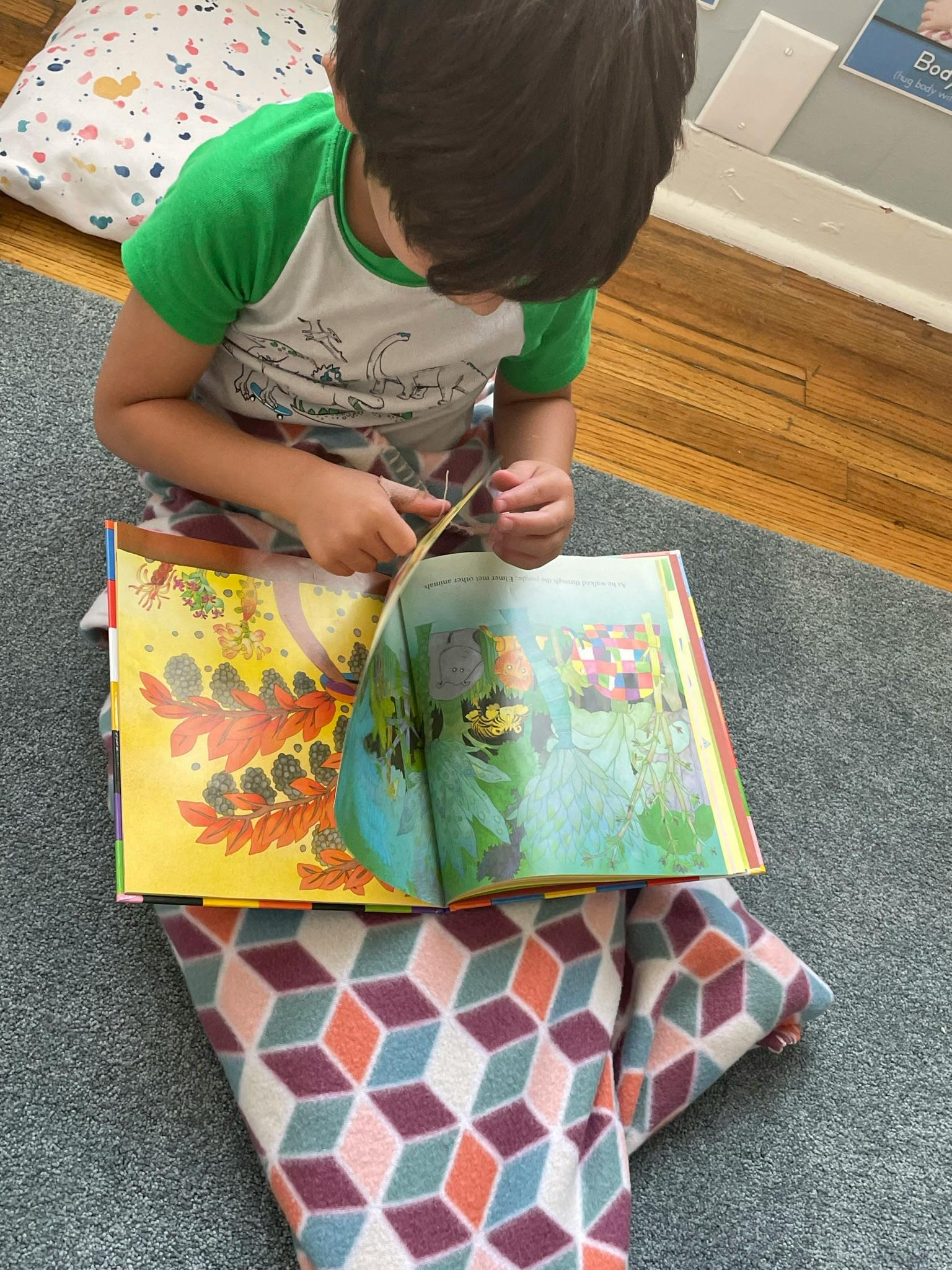 Child sitting on floor looking at an open book